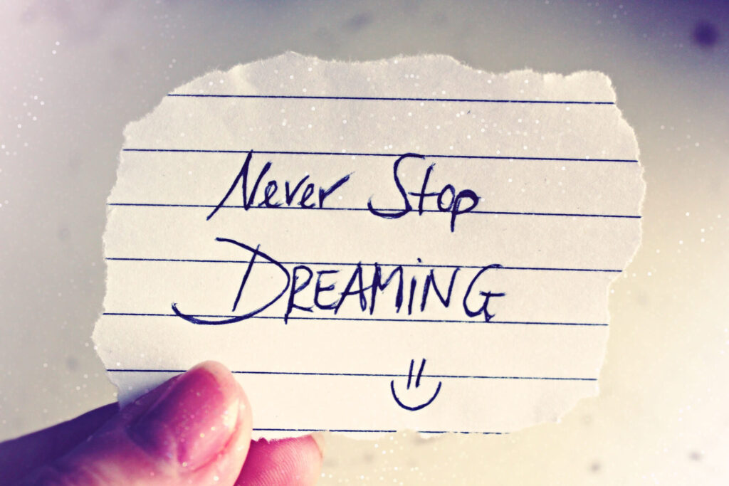 Scrap of paper with never stop dreaming written on it