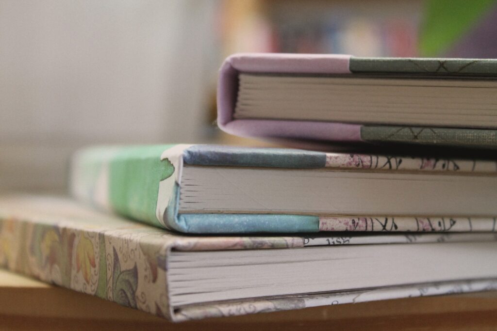 The bottom of three casebound notebooks